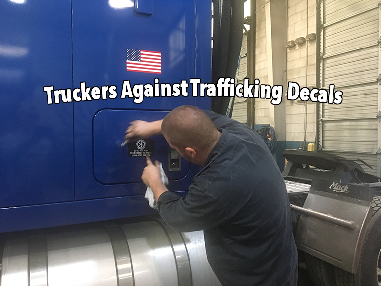 applying TAT truckers against trafficking human trafficking decals on Highway tractors